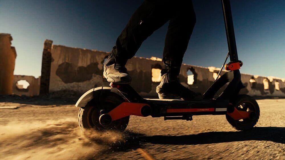 ELECTRIC SCOOTER KuKirin G3 Review showing rider on off-road terrain kicking up dust.