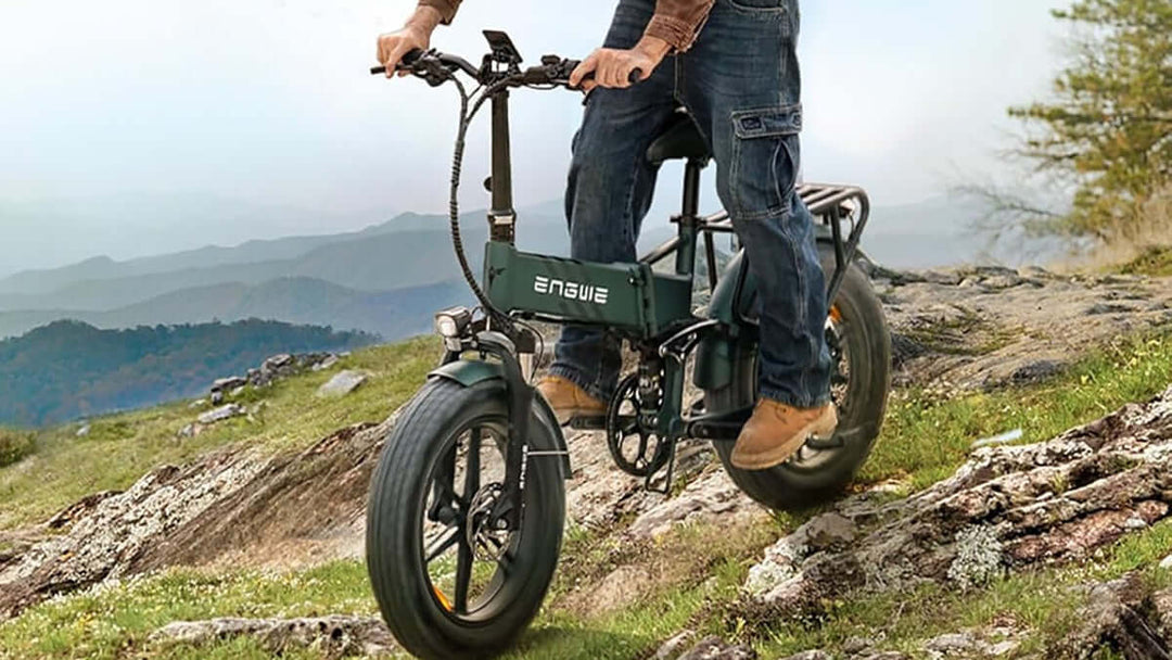 Person riding the ENGWE Engine Pro 2.0 Electric Bike on a rocky trail with mountains in the background.