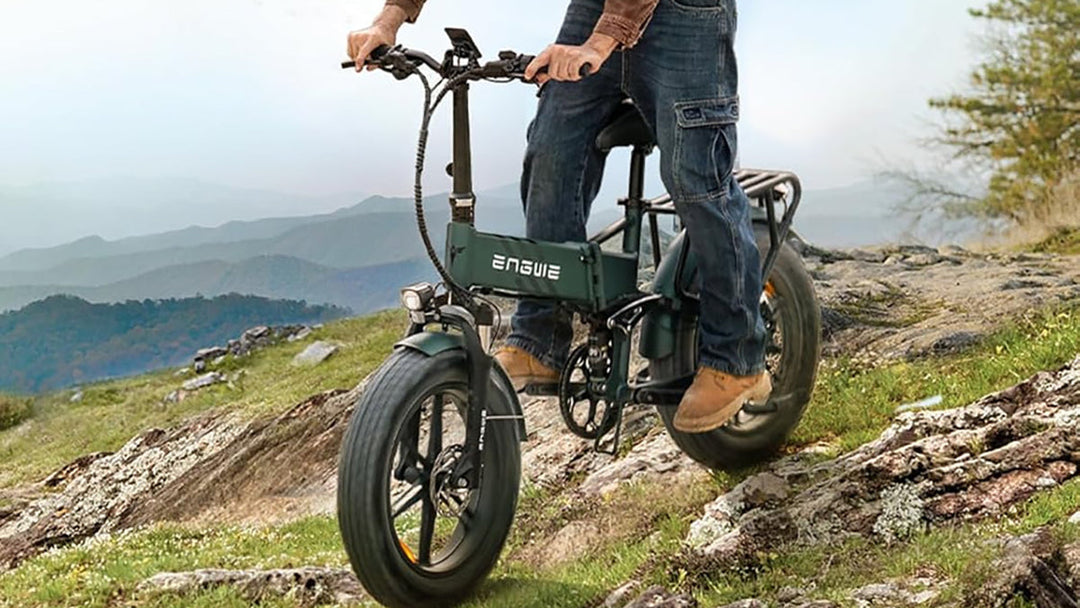 Person riding the ENGWE Engine Pro 2.0 Electric Bike on a rocky trail with mountains in the background.