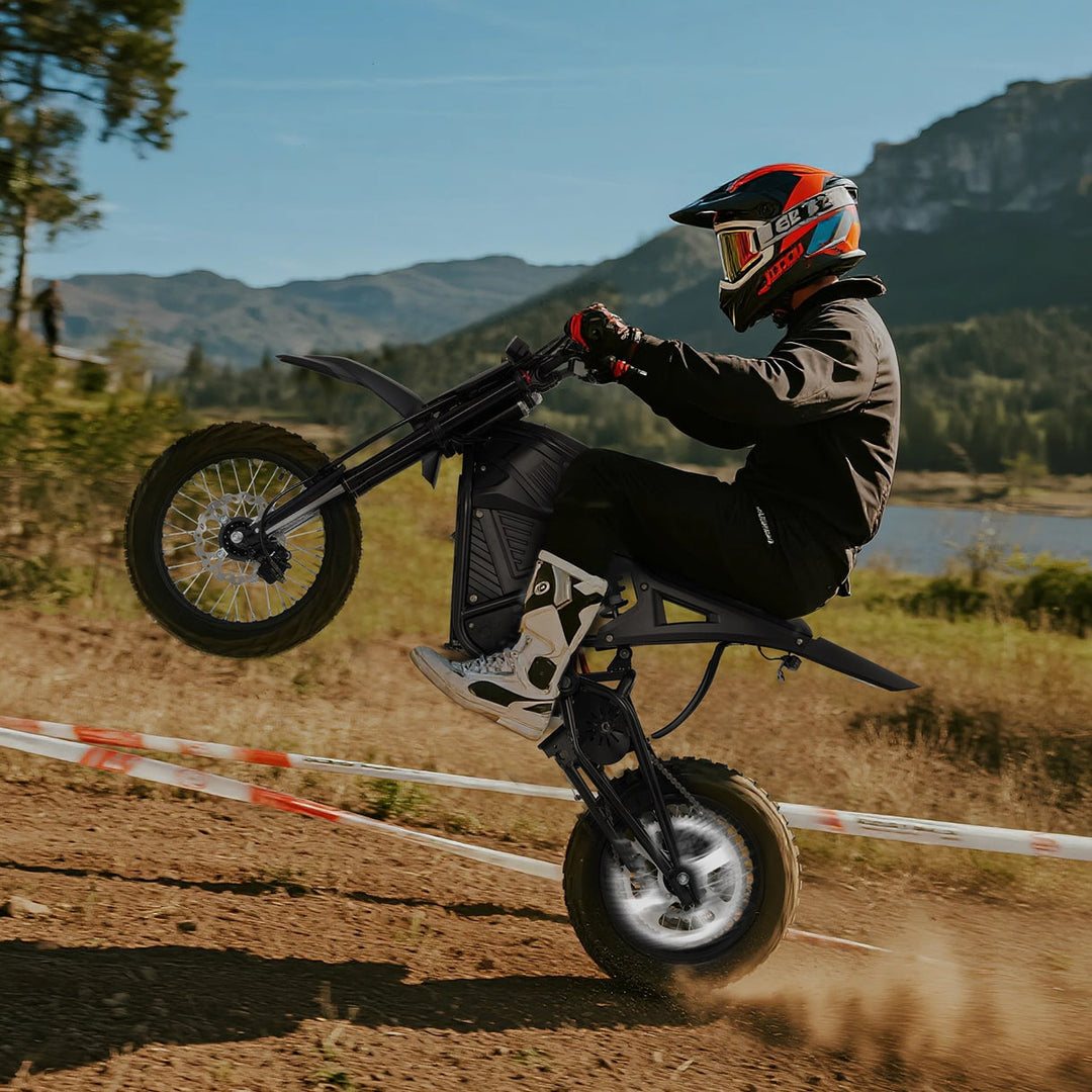 Best electric dirt bikes for teens 2026 rider performing a wheelie on an electric dirt bike in nature.