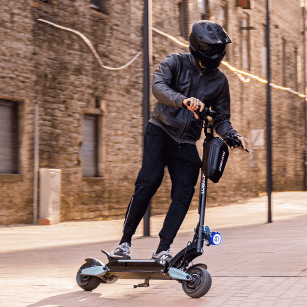 Person riding NANROBOT LIGHTNING electric scooter in urban setting, demonstrating impressive range and agility.