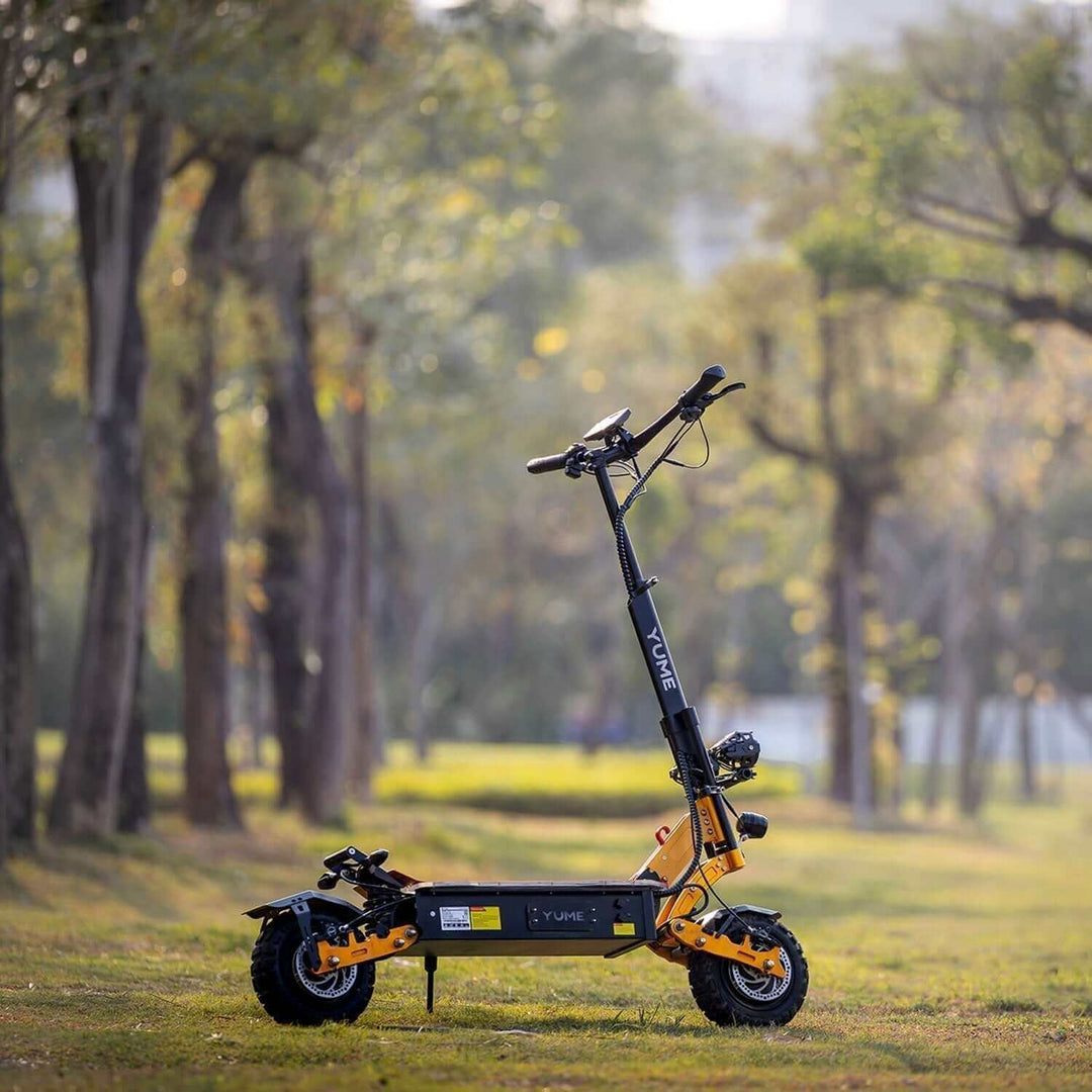 YUME X11+ FLAGSHIP REVIEW • PERFORMANCE TIER electric scooter in a park setting surrounded by trees.