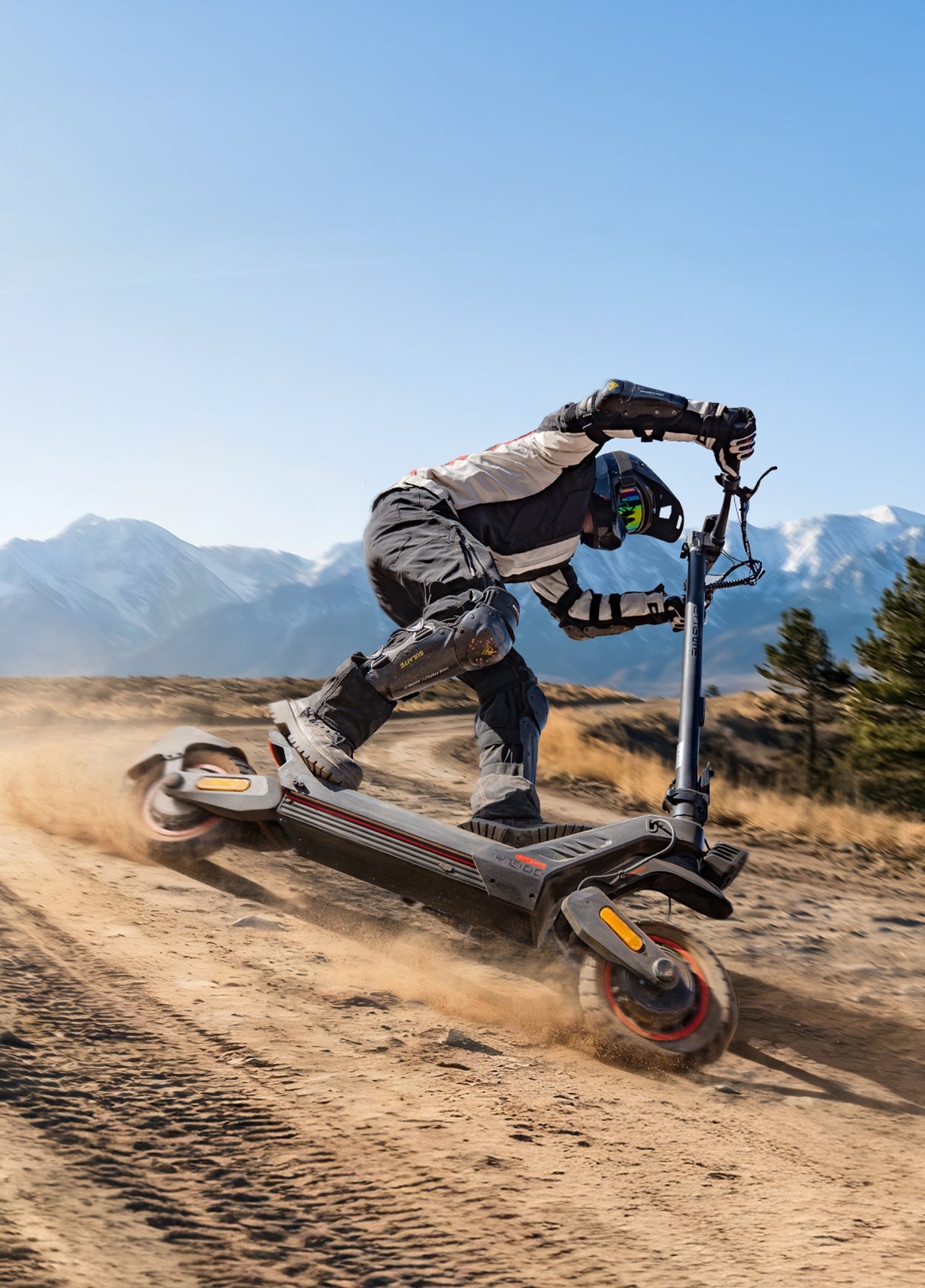 Person riding an electric scooter on a dirt trail with mountains in the background, showcasing an adventurous lifestyle.