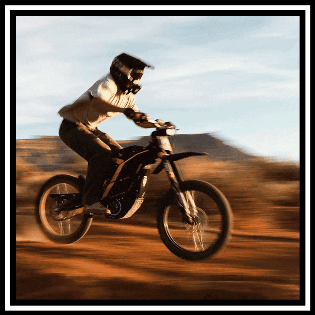 A rider on the 🇮🇪🇪🇺🇬🇧🇺🇸 79BIKE-FALCON PRO 10000W OFF-ROAD electric dirt bike performing a jump.