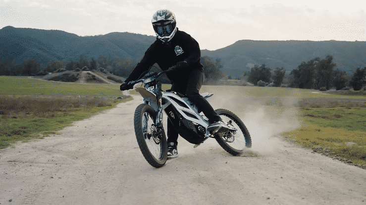 A rider on the 79BIKE-FALCON PRO OFF-ROAD ELECTRIC DIRT BIKE drifting on a dirt path with mountains in the background.