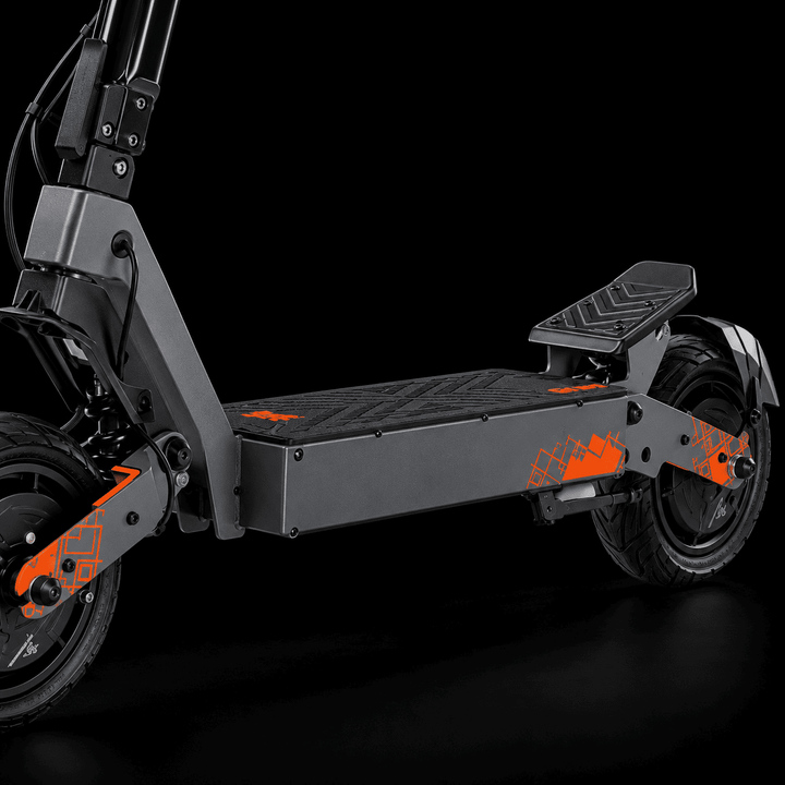 A dark gray folding Kukirin G4 Ultra Electric Scooter with bright orange graphic decals, shown from a side profile against a solid black background.