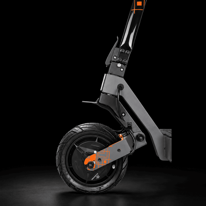 Kukirin G4 Ultra Electric Scooter - Close-up studio shot of a folding electric scooter frame and front wheel against a black background, with orange accent details on the fork and handlebar.