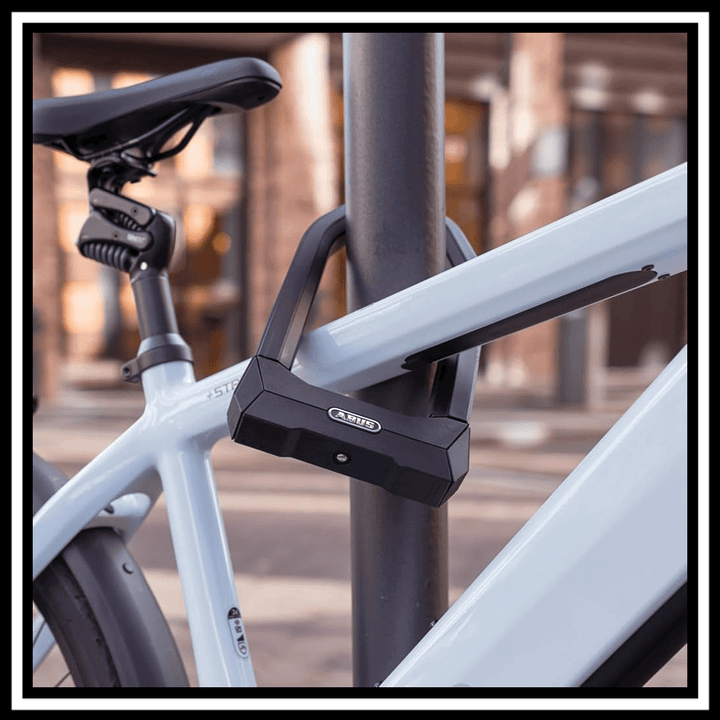 ABUS GRANIT X-PLUS BIKE LOCK securing a bicycle to a post, showcasing its durable design.