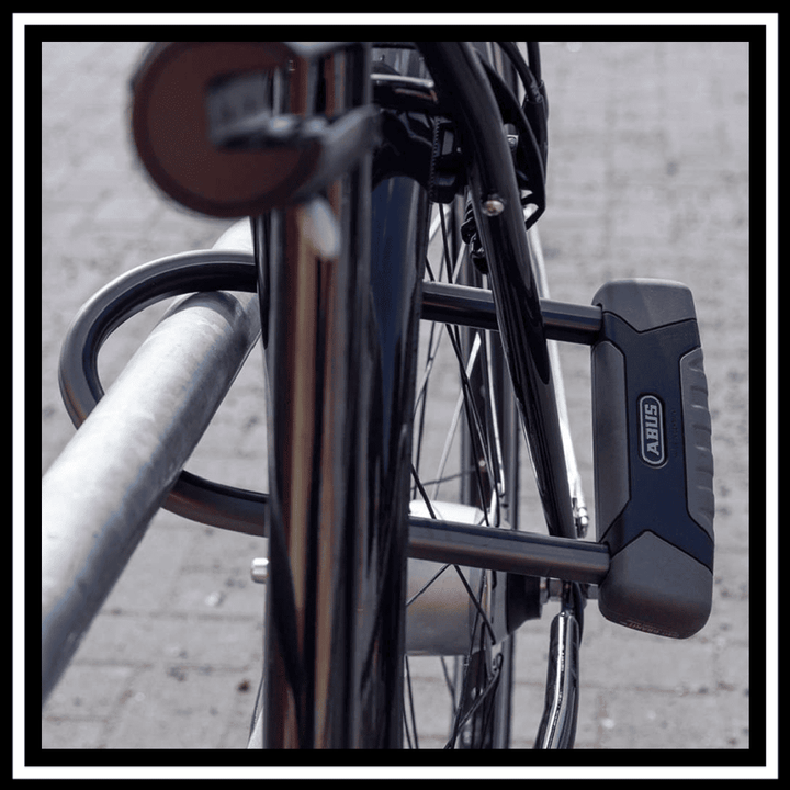 🇮🇪🇪🇺 ABUS GRANIT X-PLUS BIKE LOCK securing a bicycle to a railing, showcasing its durable design and security features.