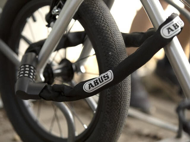 🇮🇪🇪🇺 ABUS IVEN CHAIN 8210 CHAIN LOCK securing a bicycle wheel with a combination of flexibility and security.