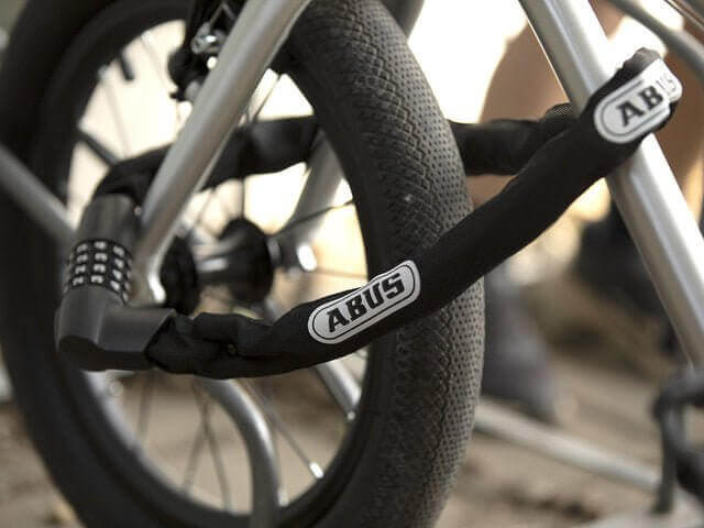🇮🇪🇪🇺 ABUS IVEN CHAIN 8210 CHAIN LOCK securing a bicycle wheel with a combination of flexibility and security.
