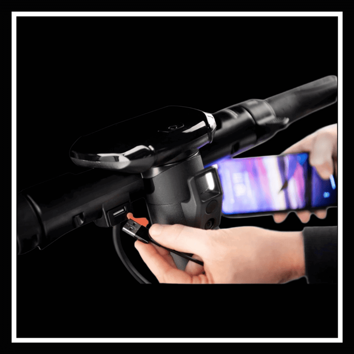 Person charging a smartphone using the USB port on the handlebar of the 🇮🇪 DUCATI PRO III electric scooter.