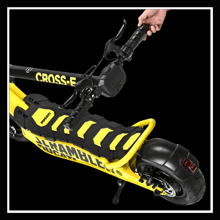 DUCATI SCRAMBLER E-CROSS electric scooter detail with handlebars and footrest in yellow and black.