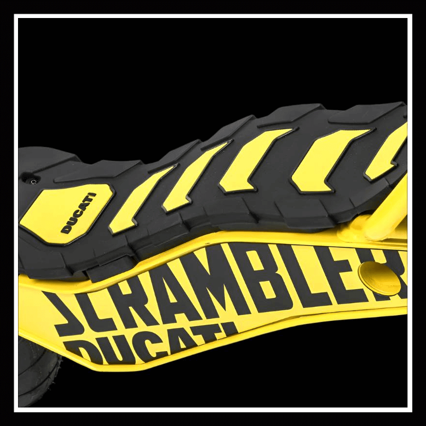 Close-up of the DUCATI SCRAMBLER E-Cross scooter with a yellow and black design on the footrest surface.