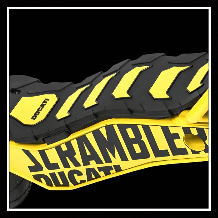 Close-up of the DUCATI SCRAMBLER E-Cross scooter with a yellow and black design on the footrest surface.