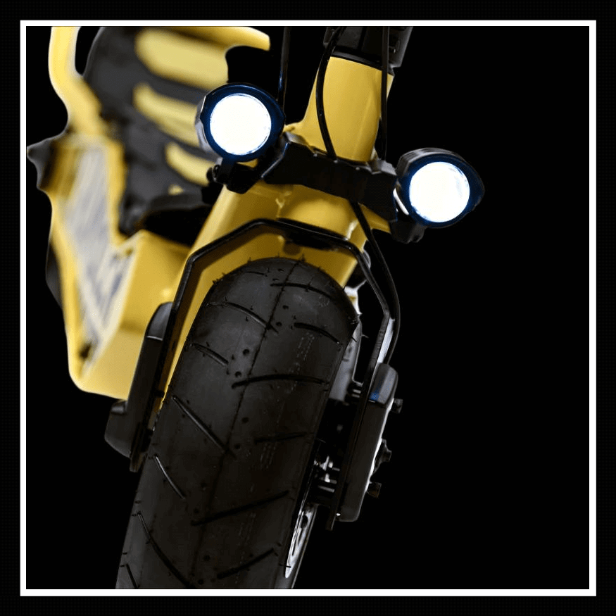 Close-up view of the front wheel and lights of the DUCATI SCRAMBLER E-Cross scooter.