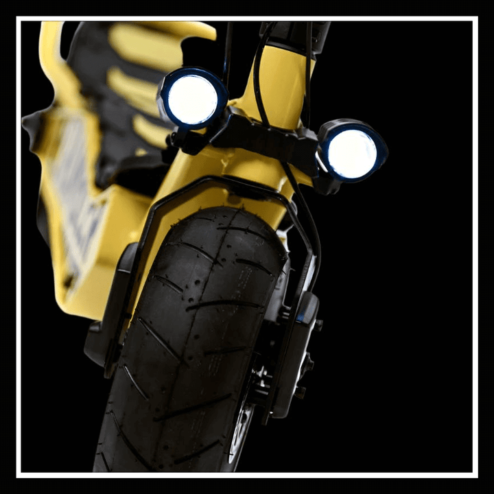 Close-up view of the front wheel and lights of the DUCATI SCRAMBLER E-Cross scooter.