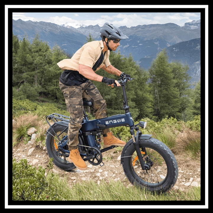 Man riding the 🇮🇪🇬🇧🇪🇺 ENGWE ENGINE 3.0 PRO BOOST e-bike on a mountain trail with greenery.