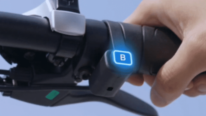 Close-up of ENGWE EP-2 BOOST ELECTRIC BIKE handlebar showing control button with blue light.