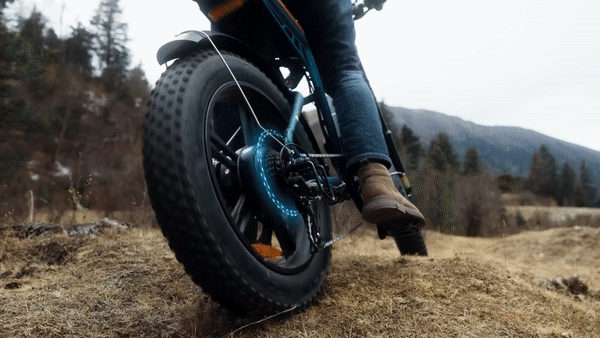 Engwe M20 electric bike riding on rough terrain highlighting its fat tires and strong performance.