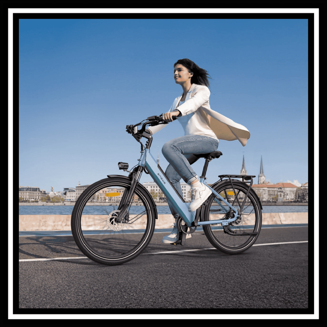 A woman riding the 🇮🇪🇬🇧🇪🇺 ENGWE P275 SE urban e-bike on a sunny day by the waterfront.