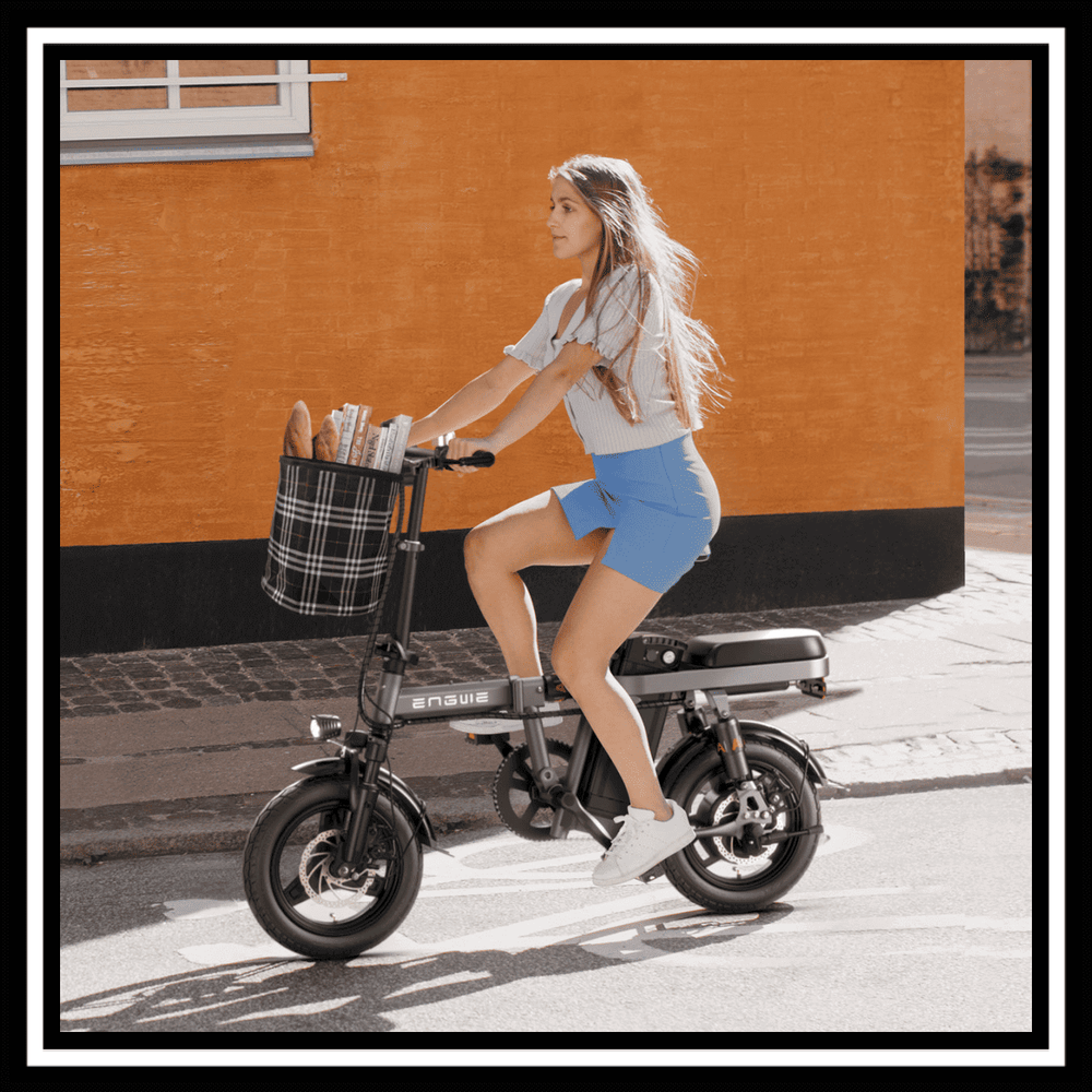 A woman riding the 🇮🇪🇬🇧🇪🇺 ENGWE T14 foldable mini-bike with a basket, showcasing urban commuting.
