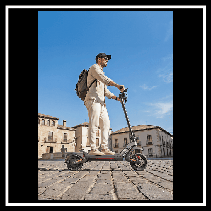 Person riding the ENGWE Y700 Electric Scooter on cobblestone street with a city backdrop.