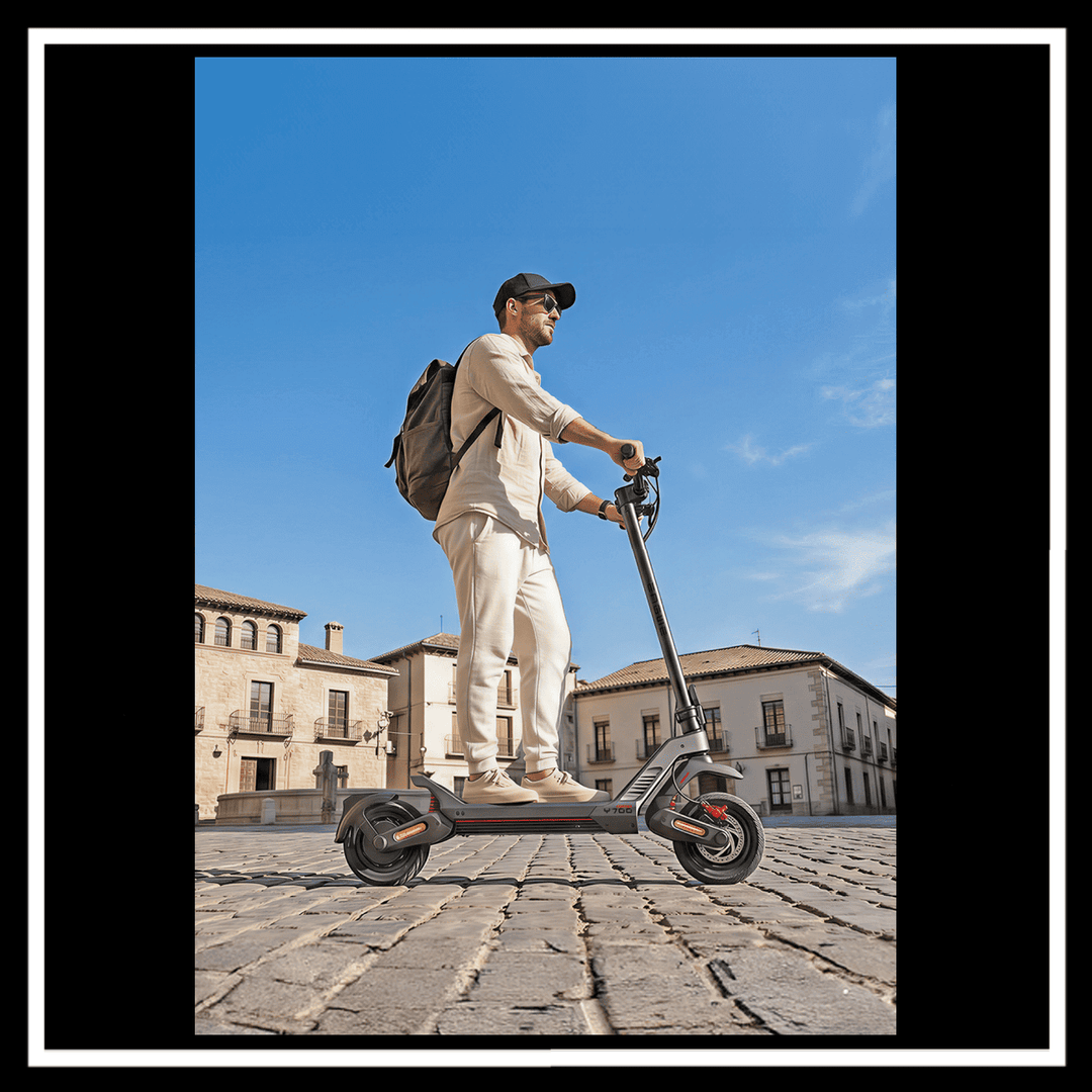Person riding the ENGWE Y700 Electric Scooter on cobblestone street with a city backdrop.