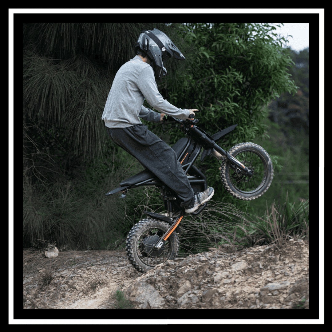 🇮🇪🇪🇺🇺🇸 GT54PRO 3000W RIDING'TIMES ELECTRIC MINI E-BIKE in action, performing a stunt on rugged terrain.