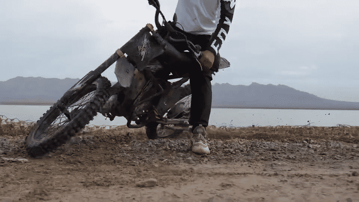 A rider performing a drift on the GT73PRO 3000W RIDING' TIMES DIRT E-BIKE on a rugged dirt track.