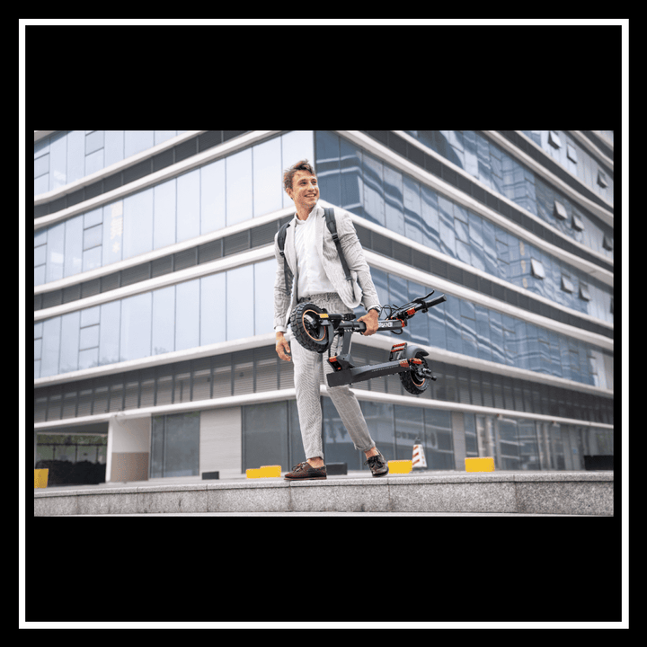 A man in a business suit carrying the 🇮🇪🇪🇺🇬🇧🇺🇸 iENYRID M4 PRO S+ electric scooter outside a modern building.