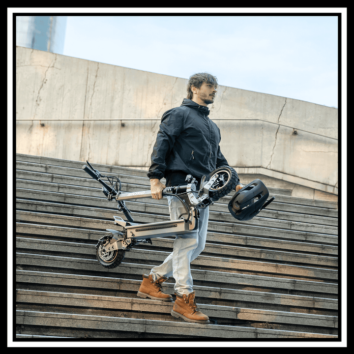 Man carrying the 🇮🇪🇪🇺🇬🇧🇺🇸 iENYRID S1 electric scooter down the stairs, showcasing its foldable design.