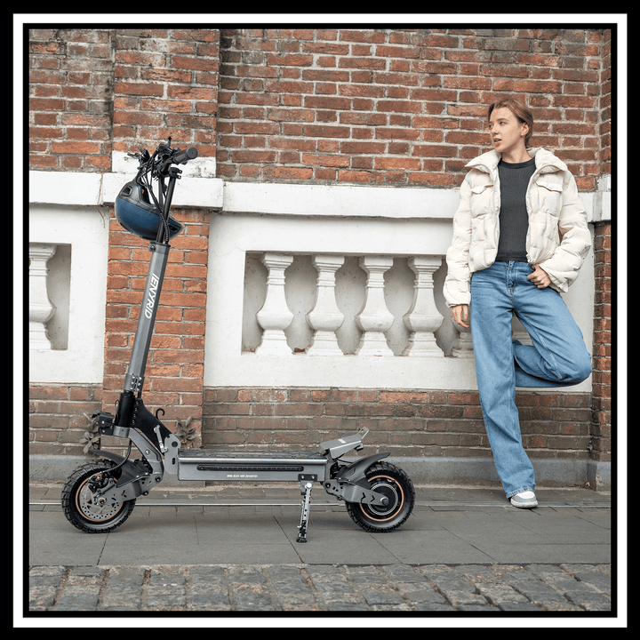 iENYRID S1 electric scooter parked beside a woman in casual attire against a brick wall.