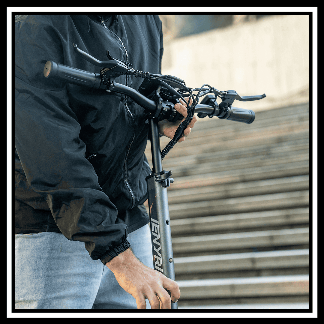 User handling the handlebars of the 🇮🇪🇪🇺🇬🇧🇺🇸 iENYRID S1 electric scooter on a set of stairs.