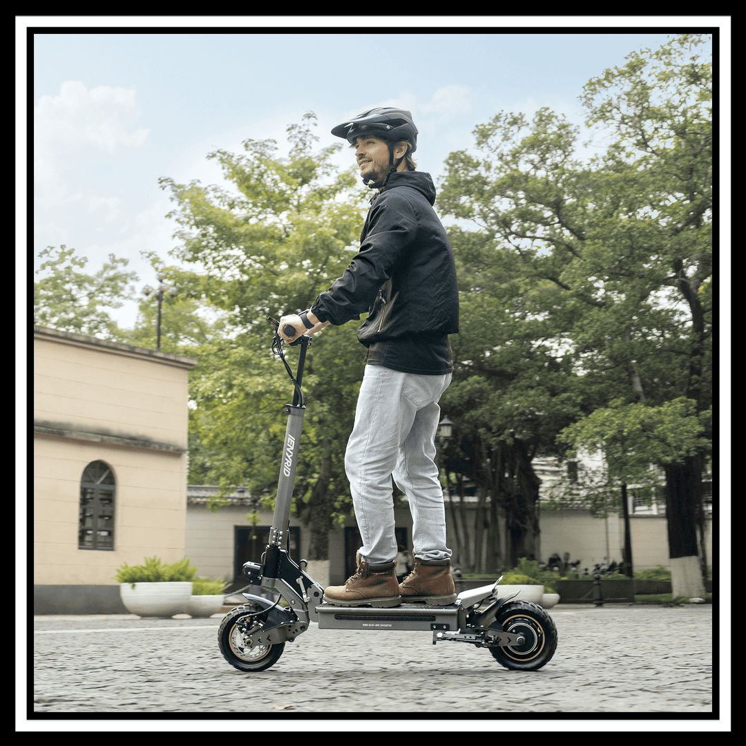 Man riding 🇮🇪🇪🇺🇬🇧🇺🇸 iENYRID S1 electric scooter on a cobblestone street.
