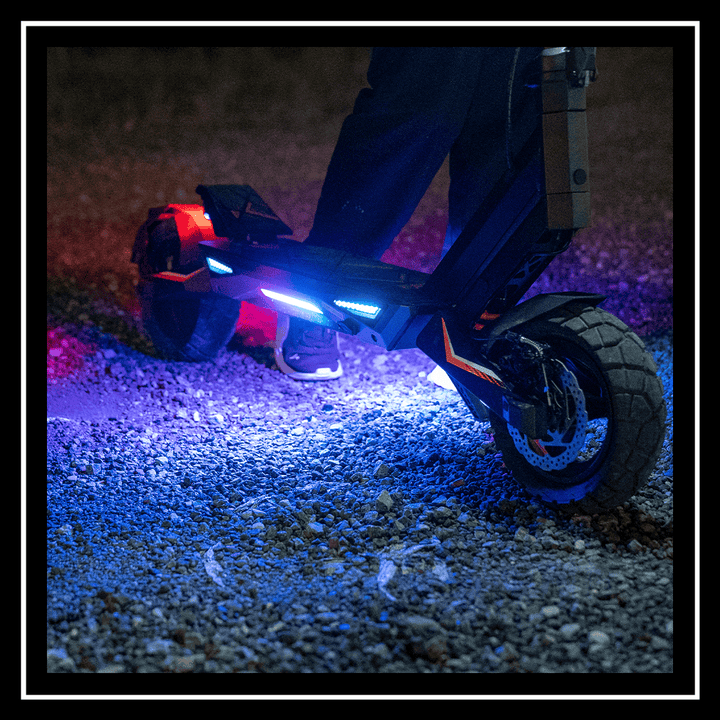 Person riding a kukirin electric scooter t3 with colorful lights on a gravel path at night.