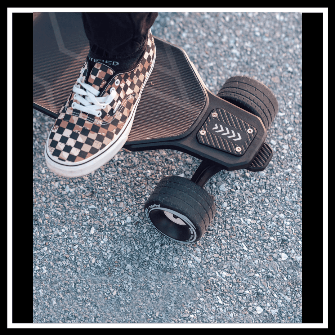 A close-up of a foot on the MAXFIND MAX6 electric skateboard, showing its robust wheels and deck.