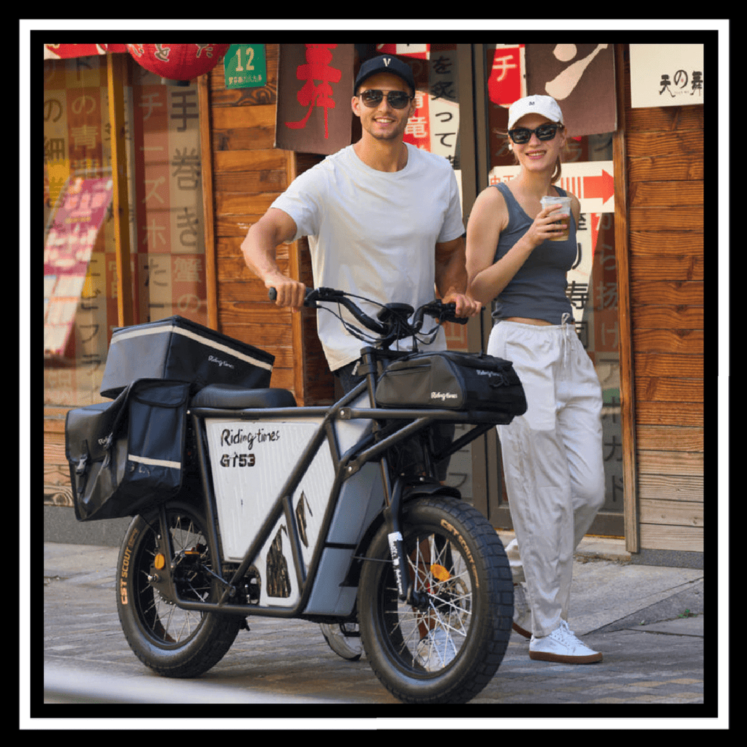 🇮🇪🇪🇺🇺🇸 GT53 2000W CARGO RIDING' TIMES E-BIKE parked in urban setting with two smiling riders.