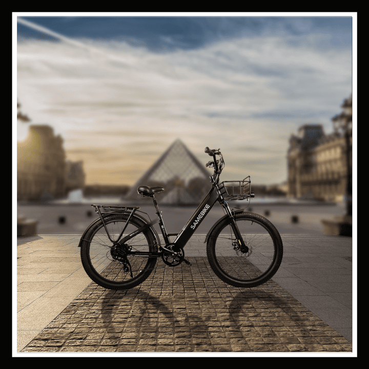 SAMEBIKE RS-A01 PLUS Electric City Bike parked in front of the Louvre Pyramid at sunset.