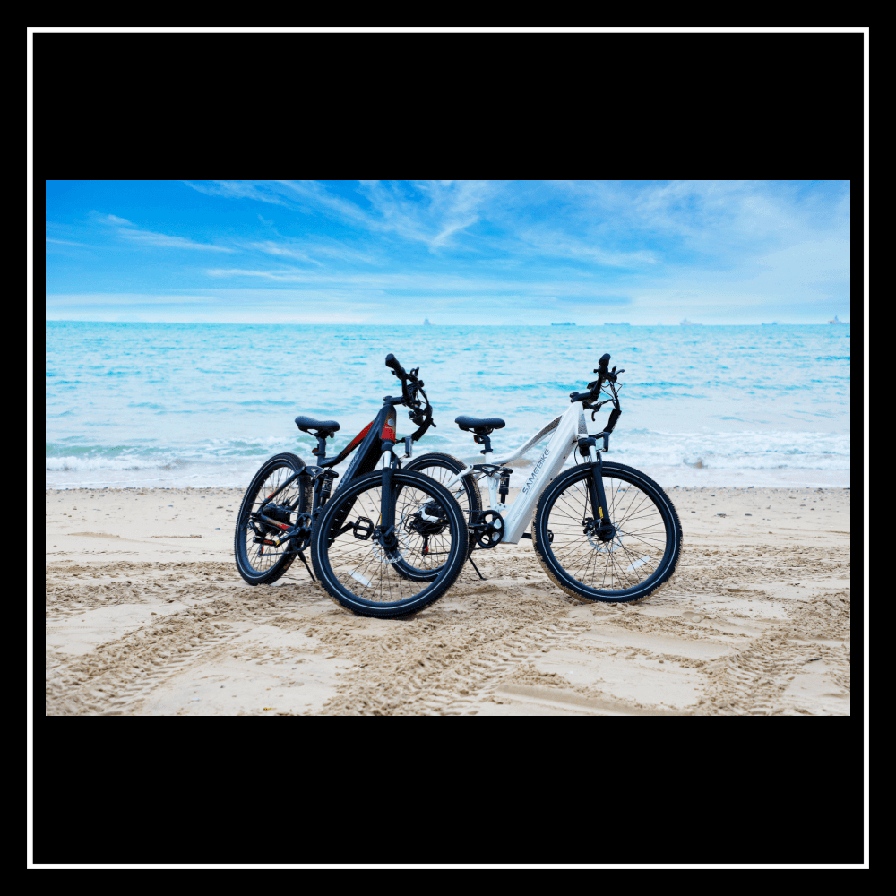SAMEBIKE XD26-II electric bikes parked on sandy beach with ocean view, showcasing sleek design and performance.