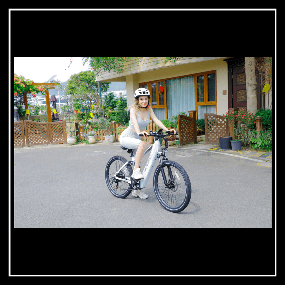 Woman riding 🇮🇪🇪🇺🇺🇸🇬🇧 SAMEBIKE XD26-II electric bike in a picturesque outdoor setting.