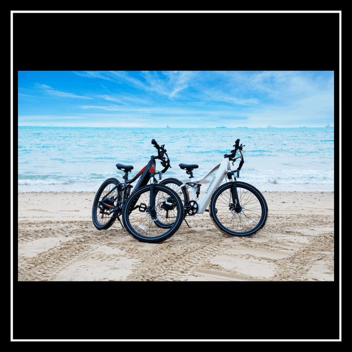 SAMEBIKE XD26-II electric bikes parked on sandy beach with ocean view, showcasing sleek design and performance.