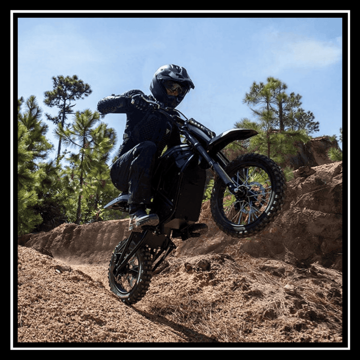 Rider on a VIPCOO H3 3500W E-DIRT BIKE climbing over sandy terrain, showcasing off-road performance.