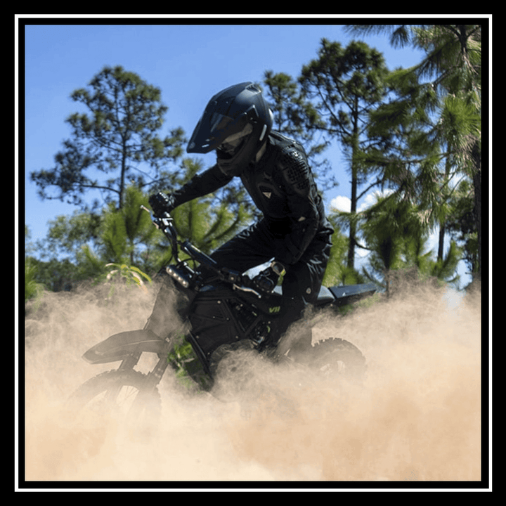 VIPCOO H3 3500W E-DIRT BIKE rider navigating through dust on an off-road trail under a blue sky.