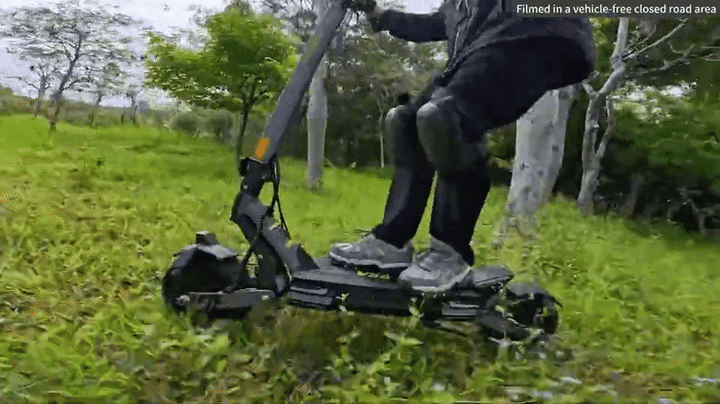 VIPCOO VS6 PRO Off-Road Electric Scooter maneuvering through grass and trees.