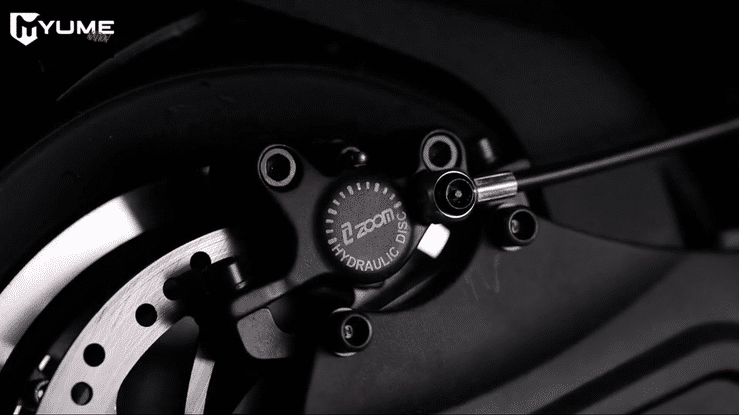 Close-up view of YUME Hawk Pro electric scooter's hydraulic brakes and components.