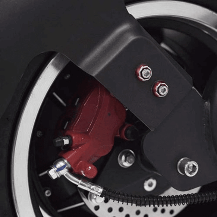 Close-up of the brake system on EAHORA M1P PLUS electric motorcycle showcasing red caliper and metallic components.