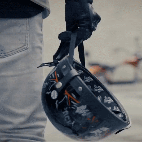 EAHORA MP1 two-seat electric motorcycle rider holding a stylish black helmet with stickers.