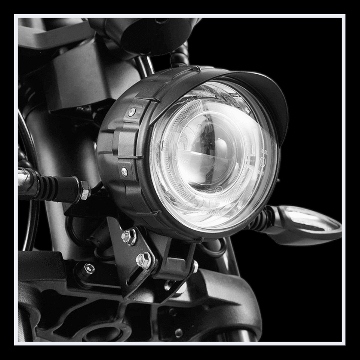 Close-up of the headlight on the INTHEZONE M1PS electric motorcycle showcasing its sleek design and bright illumination.