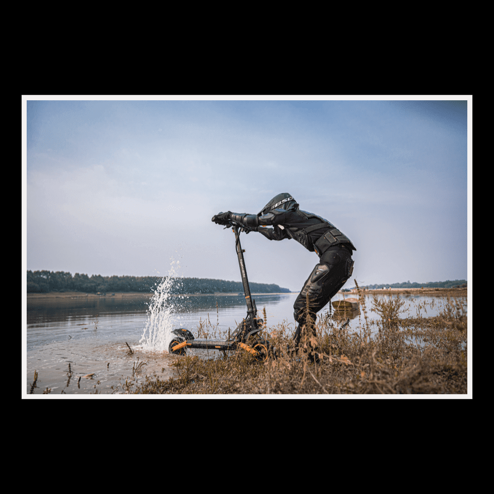 A person riding the KUKIRIN G2 Pro electric scooter near water, showcasing its design and features.